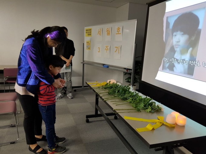▲ 나고야 세월호 3주기 추모 행사 추모행사에 참가한 아이가 엄마와 함께 헌화하고 있다