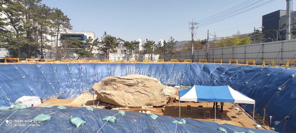 김해시 구산동 지석묘 발굴 현장의 천막과 비교해 거대한 고인돌의 크기를 가늠할 수 있다. 이번 시굴조사에서 바위 아래에서 토광묘 흔적이 발굴됐다. 