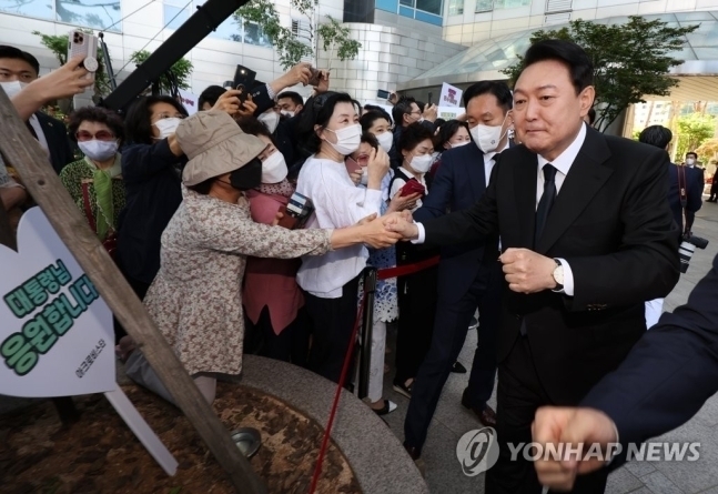윤석열 대통령이 10일 오전 제20대 대통령 취임식에 참석하기 위해 서울 서초구 서초동 자택을 나서며 주민들과 주먹 인사하고 있다.