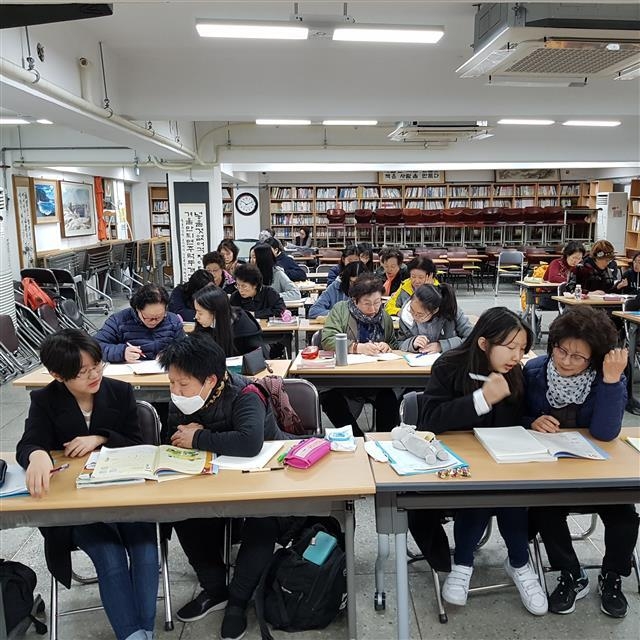 서울 마포구 일성여중 교실에서 서울여중 학생들이 어머니나 할머니뻘인 만학도들의 공부를 돕고 있다. 서울교육청 제공 